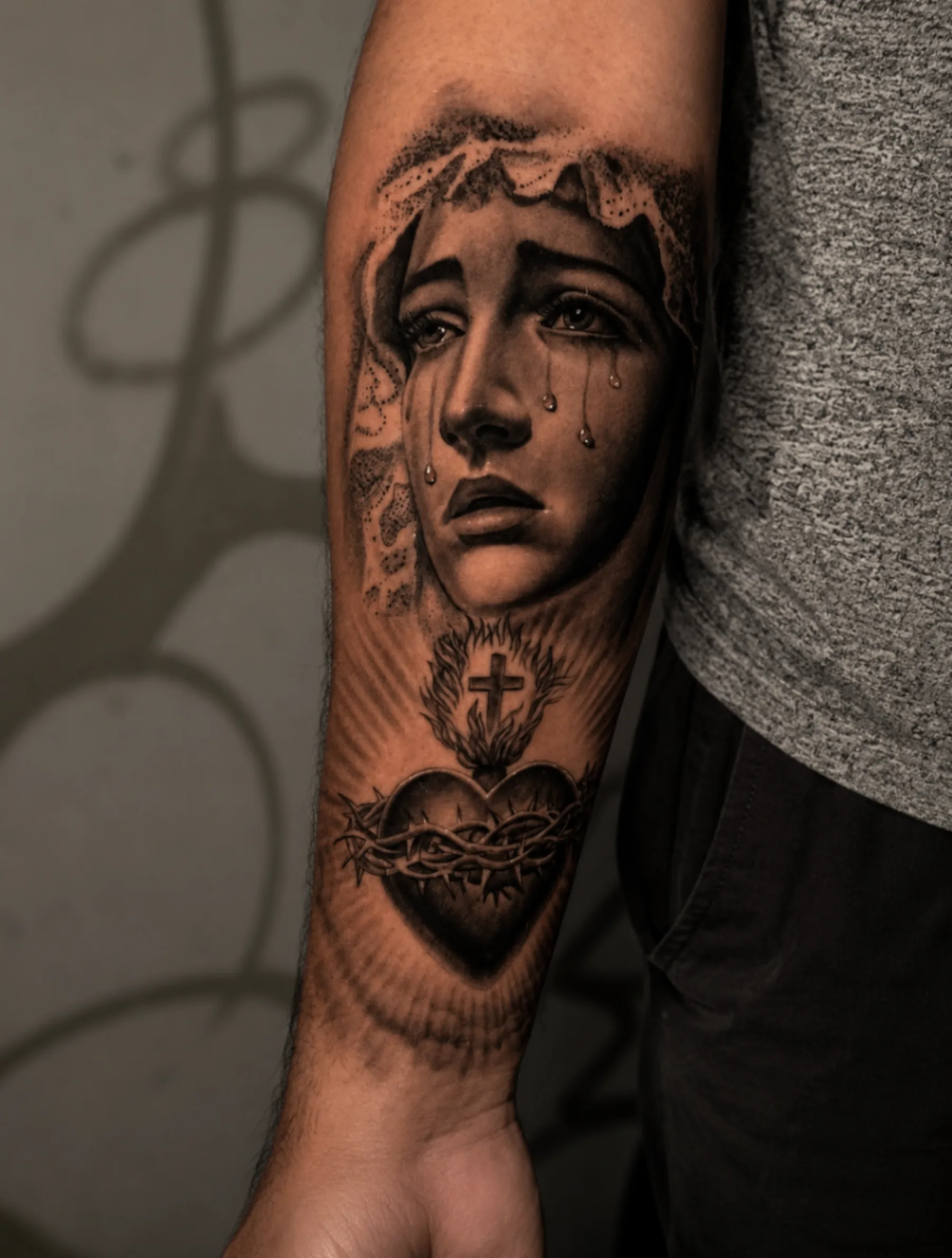 Tatuaje black and grey de retrato con corazón sagrado realizado por Santana Art